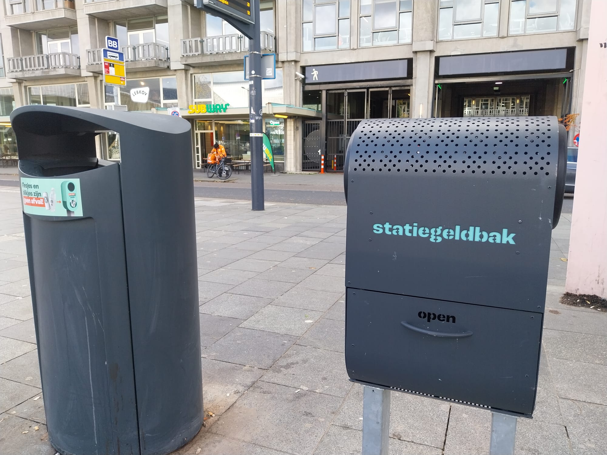 Two garbage bins next to each other in a public place. One is a conventional bin designed for accepting garbage, the other is designed to collect deposit bottles.