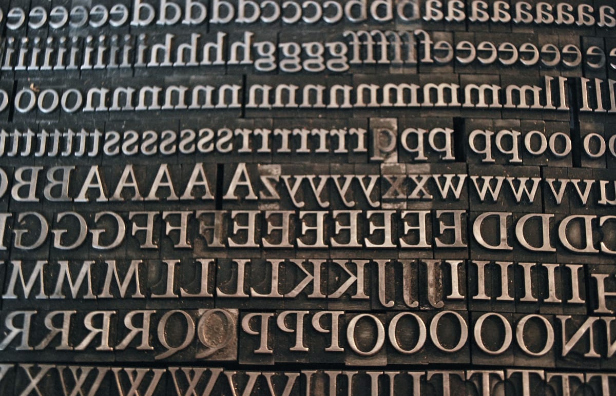 Full-screen image of letterpress type, showing both upper-case and lower-case letters.