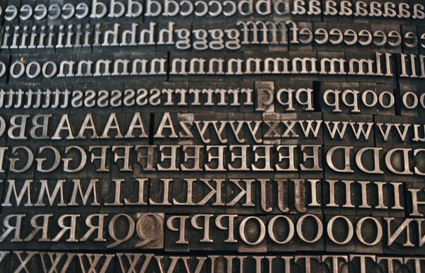 Full-screen image of letterpress type, showing both upper-case and lower-case letters.